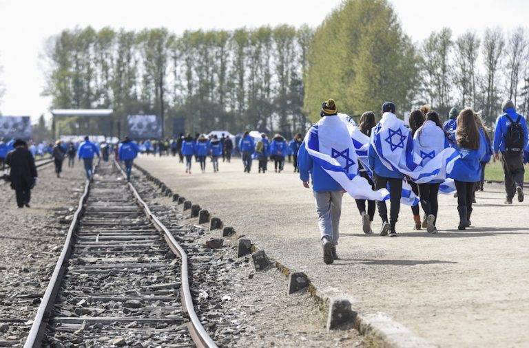 Participantes portando banderas israelíes en el antiguo campo de concentración y exterminio nazi-alemán de Auschwitz-Birkenau durante la 'Marcha de los vivos' en Oswiecim en Cracovia, Polonia el 24 de abril de 2017. (Omar Marques / Agencia Anadolu / Getty Images vía JTA)