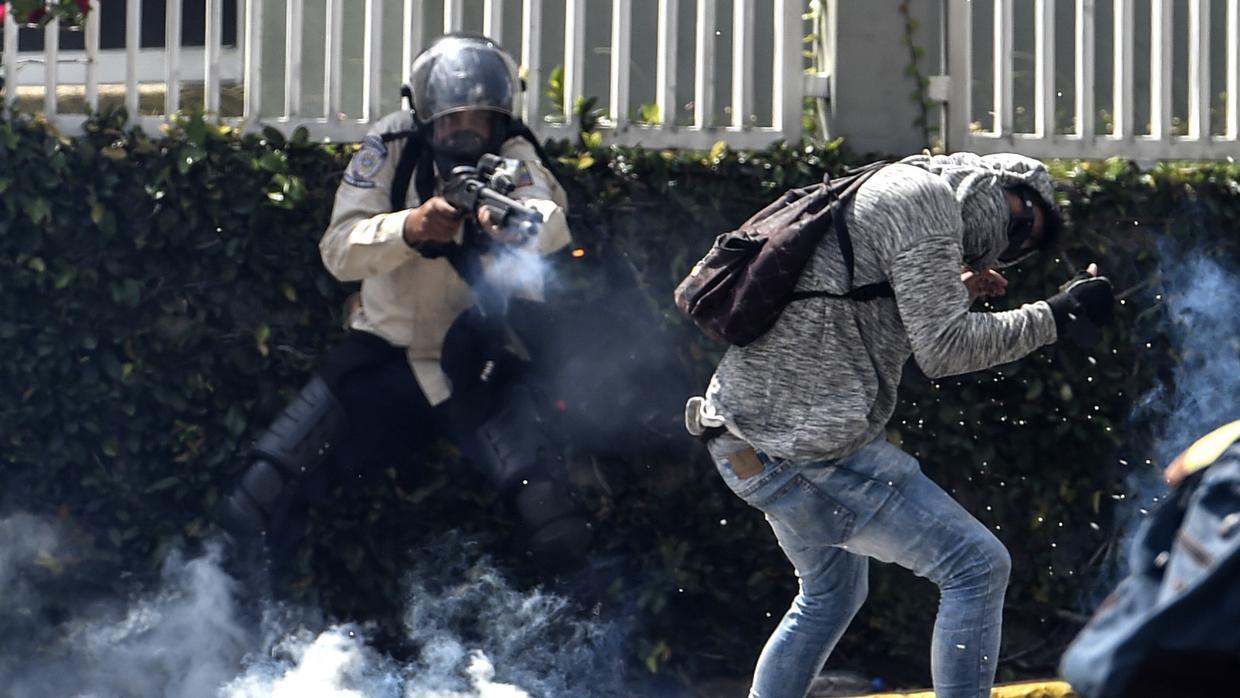 Un policía nacional dispara a quemarropa contra un manifestante en Caracas. Juan Barreto / AFP / Getty Images
