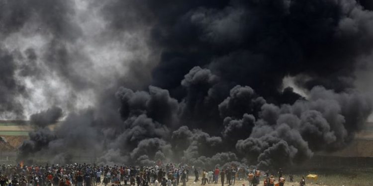 Los islamistas palestinos queman neumáticos en la valla fronteriza con Israel, al este de Jabalia, en la ciudad central de Gaza, el 13 de abril de 2018. (AFP PHOTO / MOHAMMED ABED)