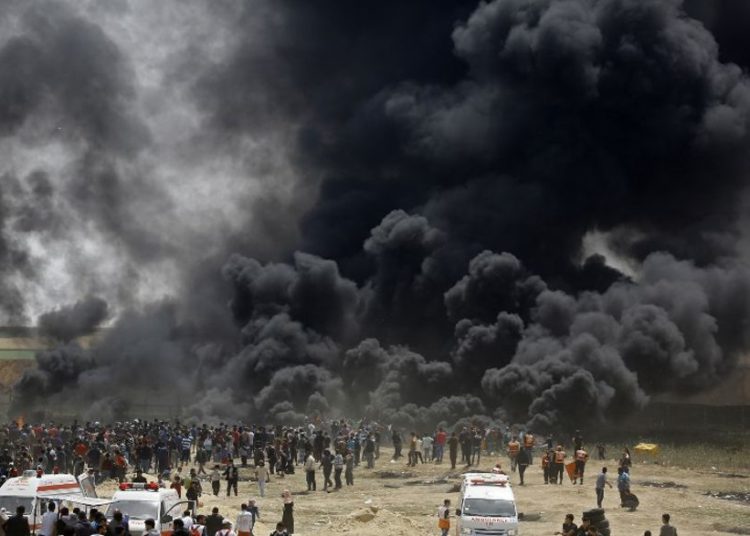 Los islamistas palestinos queman neumáticos en la valla fronteriza con Israel, al este de Jabalia, en la ciudad central de Gaza, el 13 de abril de 2018. (AFP PHOTO / MOHAMMED ABED)