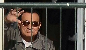 El ex presidente egipcio Hosni Mubarak saluda a sus partidarios desde el balcón de su habitación en el hospital militar Maadi en El Cairo el 29 de noviembre de 2014. (AFP / periódico Al-Watan / Mohamed Nabil)