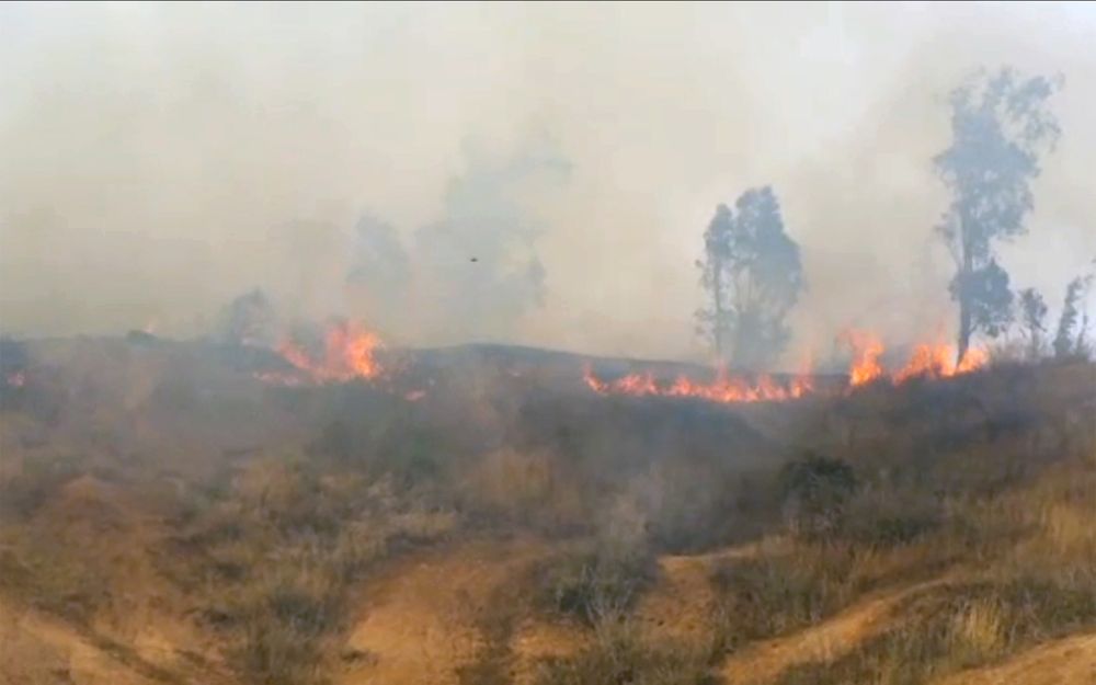 El humo y las llamas se elevan desde las praderas del Kibbutz Be'eri en el sur de Israel después de que los islamistas palestinos volaron una cometa cargada con una bomba incendiaria sobre la frontera el 2 de mayo de 2018. (Captura de pantalla / Rafi Bavian)