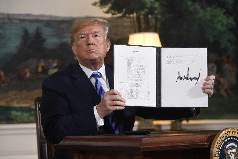 El presidente de los Estados Unidos, Donald Trump, firma un documento que restablece las sanciones contra Irán después de anunciar la retirada estadounidense del acuerdo nuclear iraní, en la sala de recepción diplomática en la Casa Blanca en Washington, DC, el 8 de mayo de 2018. (AFP PHOTO / SAUL LOEB)