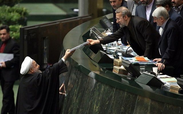 El presidente iraní, Hassan Rouhani, izquierda, presenta el presupuesto anual propuesto al presidente del Parlamento, Ali Larijani Ali Larijani, en la capital, Teherán, el 17 de enero de 2016, luego de que se levantaran las sanciones bajo el acuerdo nuclear de Teherán con las potencias mundiales. (AFP / Atta Kenare)