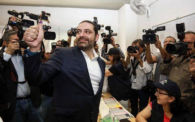 El primer ministro libanés Saad Hariri (CL) hace un gesto de aprobación con su pulgar manchado de tinta después de votar en una mesa electoral en la capital, Beirut, el 6 de mayo de 2018, mientras el país votaba en las primeras elecciones parlamentarias en nueve años. (AFP Photo / Anwar Amro)