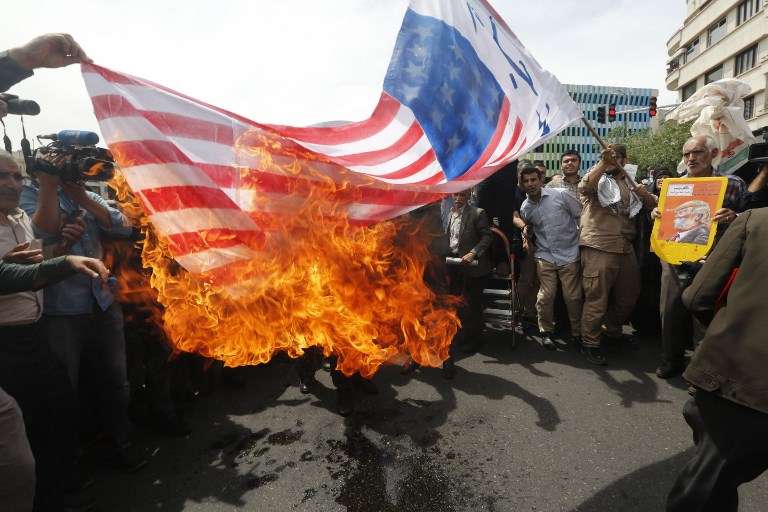 Los iraníes prendieron fuego a una bandera improvisada de los EE. UU. durante una manifestación después de la oración del viernes en la capital, Teherán, el 11 de mayo de 2018. (AFP)