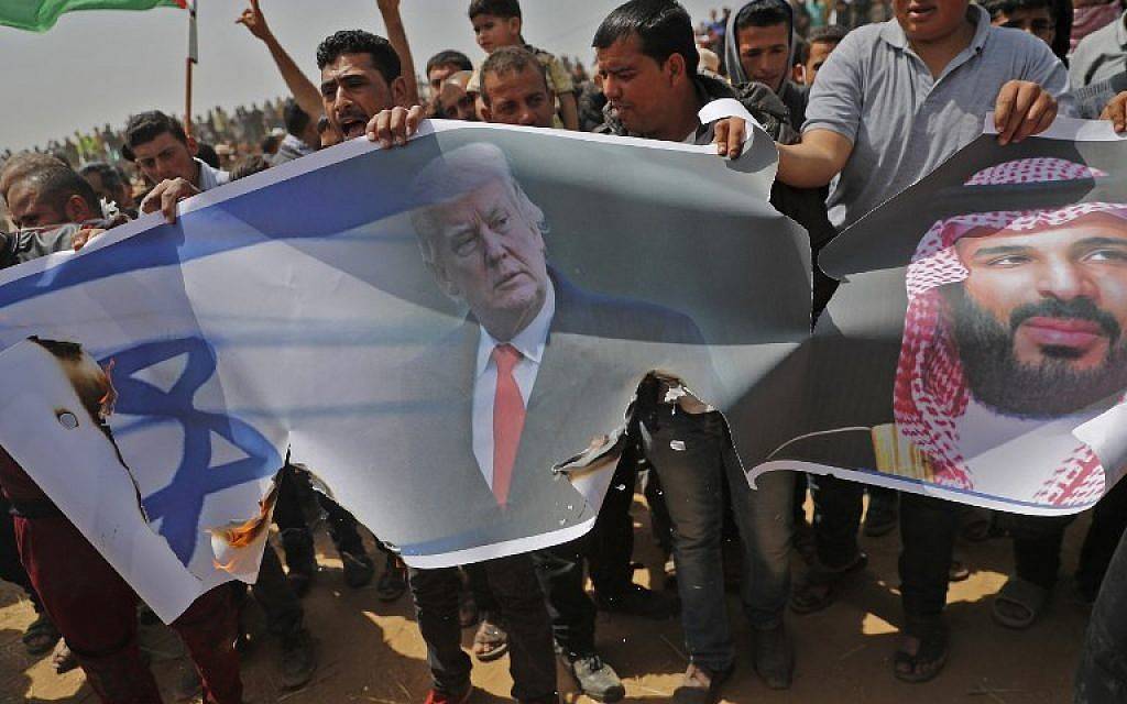 Los islamistas palestinos se preparan para prender fuego en una bandera y retratos del presidente estadounidense Donald Trump y el príncipe heredero saudí Mohammed bin Salman durante una manifestación violenta en la valla fronteriza con Israel, al este de Khan Yunis, en la ciudad sureña de Gaza, el 13 de abril de 2018. ( AFP PHOTO / Thomas COEX)