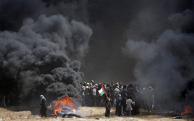 Los palestinos incendian neumáticos cerca de la frontera entre la franja de Gaza e Israel, al este de la ciudad de Gaza, el 14 de mayo de 2018. (AFP Photo / Thomas Coex)