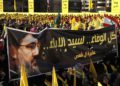 Los partidarios del líder de Hezbolá Hassan Nasrallah sostienen una pancarta con su retrato y palabras en árabe que dicen: “Toda la lealtad al hombre de la nobleza” durante un discurso de campaña electoral en un suburbio del sur de Beirut, Líbano. (AP / Hussein Malla)