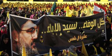 Los partidarios del líder de Hezbolá Hassan Nasrallah sostienen una pancarta con su retrato y palabras en árabe que dicen: “Toda la lealtad al hombre de la nobleza” durante un discurso de campaña electoral en un suburbio del sur de Beirut, Líbano. (AP / Hussein Malla)