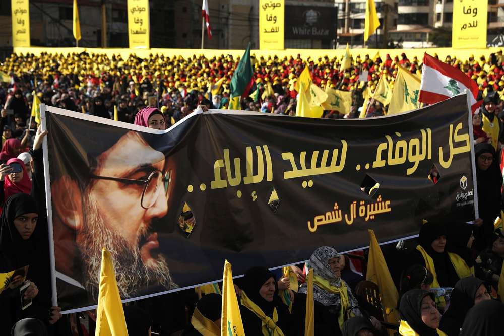 Los partidarios del líder de Hezbolá Hassan Nasrallah sostienen una pancarta con su retrato y palabras en árabe que dicen: “Toda la lealtad al hombre de la nobleza” durante un discurso de campaña electoral en un suburbio del sur de Beirut, Líbano. (AP / Hussein Malla)