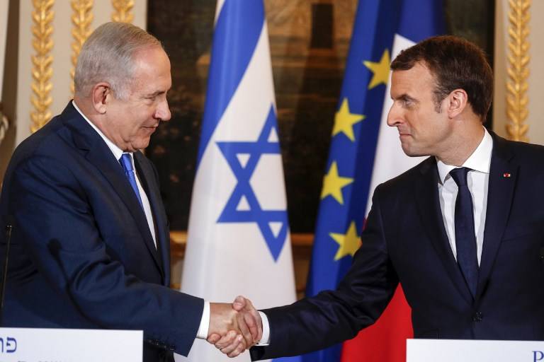 El primer ministro Benjamin Netanyahu (L) y el presidente francés Emmanuel Macron se dan la mano durante una conferencia de prensa conjunta tras su reunión en el Palacio del Elíseo en París el 10 de diciembre de 2017. (AFP / Pool / Philippe Wojazer)