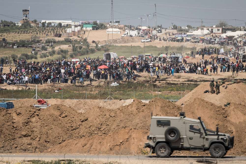 Soldados de las FDI en el lado israelí de la frontera con la Franja de Gaza mientras miles de palestinos se manifiestan cerca de la cerca fronteriza, el 6 de abril de 2018. (Hadas Parush / Flash 90)