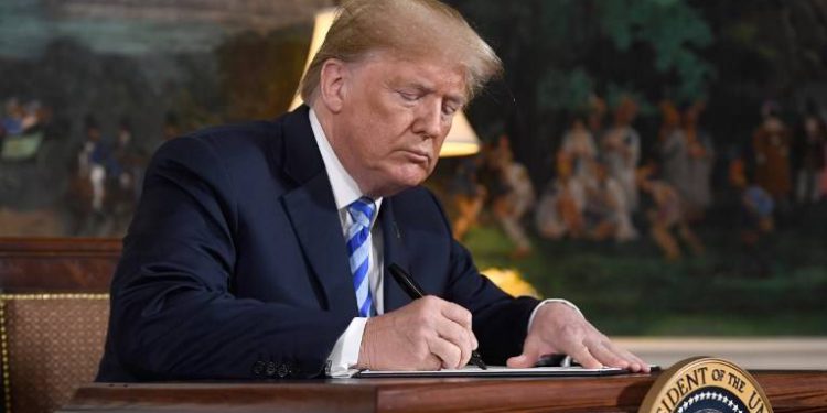 El presidente estadounidense Donald Trump firma un documento que restablece las sanciones contra Irán después de anunciar la retirada de Estados Unidos del acuerdo nuclear de Irán en la sala de recepción diplomática en la Casa Blanca en Washington, DC, el 8 de mayo de 2018. (AFP / Saul Loeb)