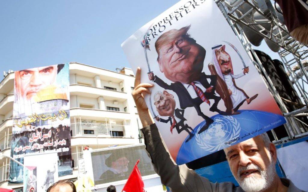 Ilustrativo: un hombre iraní sostiene un póster con imágenes del primer ministro israelí Benjamin Netanyahu, el presidente estadounidense Donald Trump y el rey saudí Salam durante un desfile que marca el día de al-Quds (Jerusalén) en Teherán el 23 de junio de 2017. (AFP PHOTO / STRINGER)