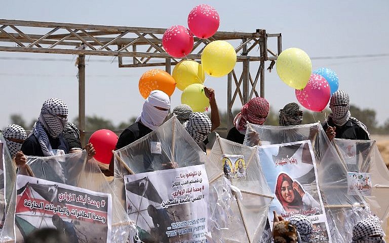 Los palestinos cargan cometas y globos con material inflamable para volar hacia Israel, en la frontera entre Israel y Gaza en al-Bureij, en el centro de la Franja de Gaza, el 14 de junio de 2018. (AFP Photo / Mahmud Hams)