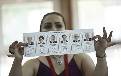 Un miembro del comité electoral muestra una boleta que muestra un voto para Selahattin Demirtas, candidato presidencial del Partido Democrático Popular (HDP) en un colegio electoral durante las elecciones presidenciales y parlamentarias turcas en Estambul el 24 de junio de 2018. (AFP PHOTO / Yasin AKGUL)
