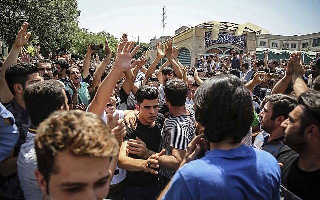 Un grupo de manifestantes grita consignas en la entrada principal del antiguo Gran Bazar en Teherán, Irán, el 25 de junio de 2018. (Agencia de noticias del trabajo iraní vía AP)