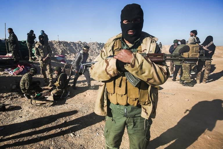 Ilustrativo: Un combatiente enmascarado de los paramilitares Hashed al-Shaabi (Movilización popular) posa para una fotografía portando un rifle de asalto Kalashnikov por posiciones defensivas en las afueras de Tal Afar al oeste de Mosul, el 18 de febrero de 2017. (AFP Photo / Ahmad Al -Rubaye)