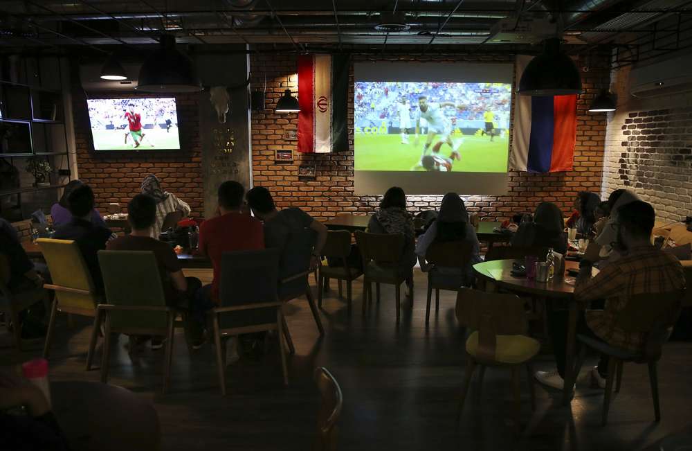 Los iraníes miran a la selección nacional de fútbol jugar contra Marruecos en la Copa Mundial 2018, en un café en el centro de Teherán, Irán, el 15 de junio de 2018. (AP Photo / Vahid Salemi)