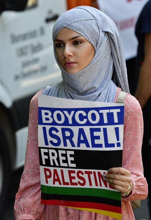 Un manifestante sostiene un letrero que dice “Boicot a Israel, Palestina libre” durante una manifestación en el Día al-Quds en Berlín, el 9 de junio de 2018. (AFP PHOTO / Tobias SCHWARZ)