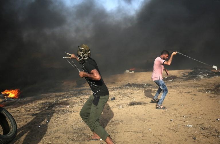 Islamistas palestinos utilizan hondas para arrojar piedras a las fuerzas israelíes durante la violencia árabe a lo largo de la frontera con la Franja de Gaza al este de Khan Yunis el 18 de mayo de 2018. (AFP PHOTO / SAID KHATIB)