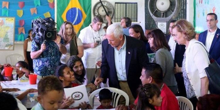 Mike Pence junto a refugiados venezolanos en Brasil (AFP)