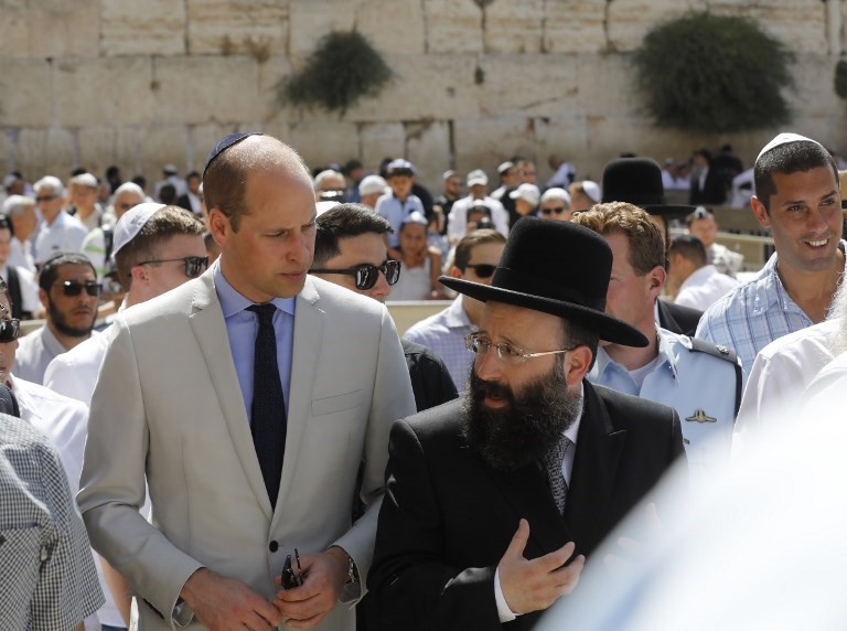 El príncipe Guillermo (CL) de Gran Bretaña camina junto al jefe del Muro de los Lamentos, Rabino Shmuel Rabinovitch (R) durante una visita al Muro Occidental, el lugar más sagrado donde los judíos pueden orar, en la Ciudad Vieja de Jerusalén el 28 de junio de 2018 (AFP PHOTO / Menahem KAHANA)