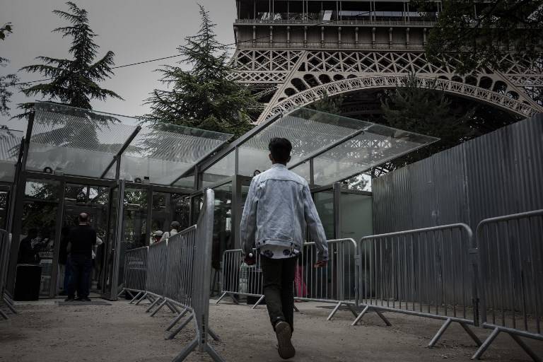 Un visitante camina el 14 de junio de 2018 a una de las nuevas puertas de entrada ubicadas alrededor de la torre Eiffel en París como medida antiterrorista. (AFP / Philippe Lopez)
