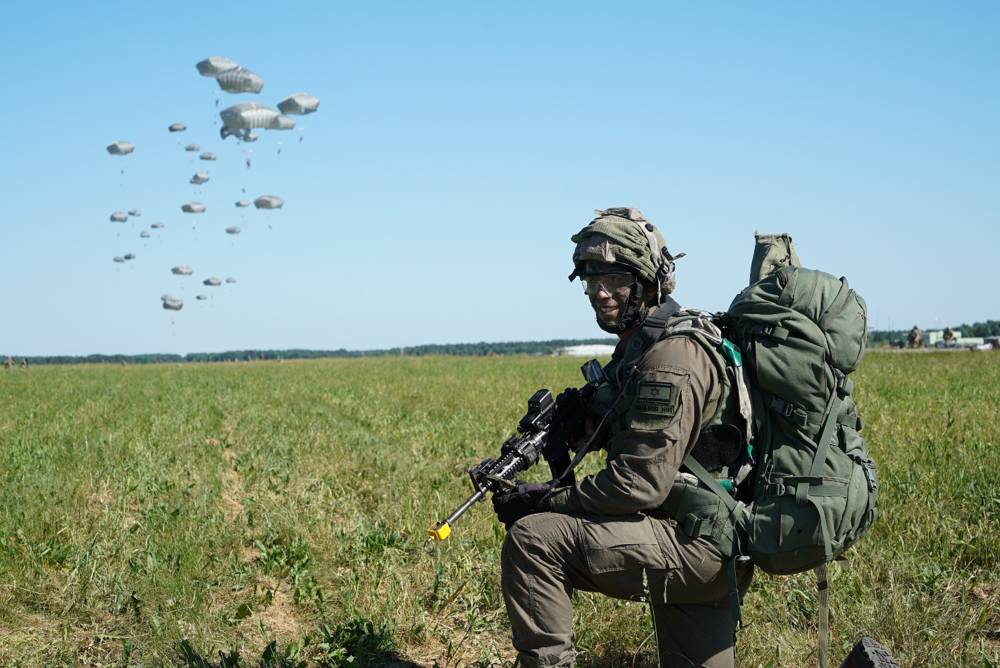 Un soldado israelí toma posición mientras otros paracaidistas aterrizan detrás de él durante el ejercicio Swift Response dirigido por Estados Unidos en Europa en junio de 2018. (Fuerzas de Defensa de Israel)