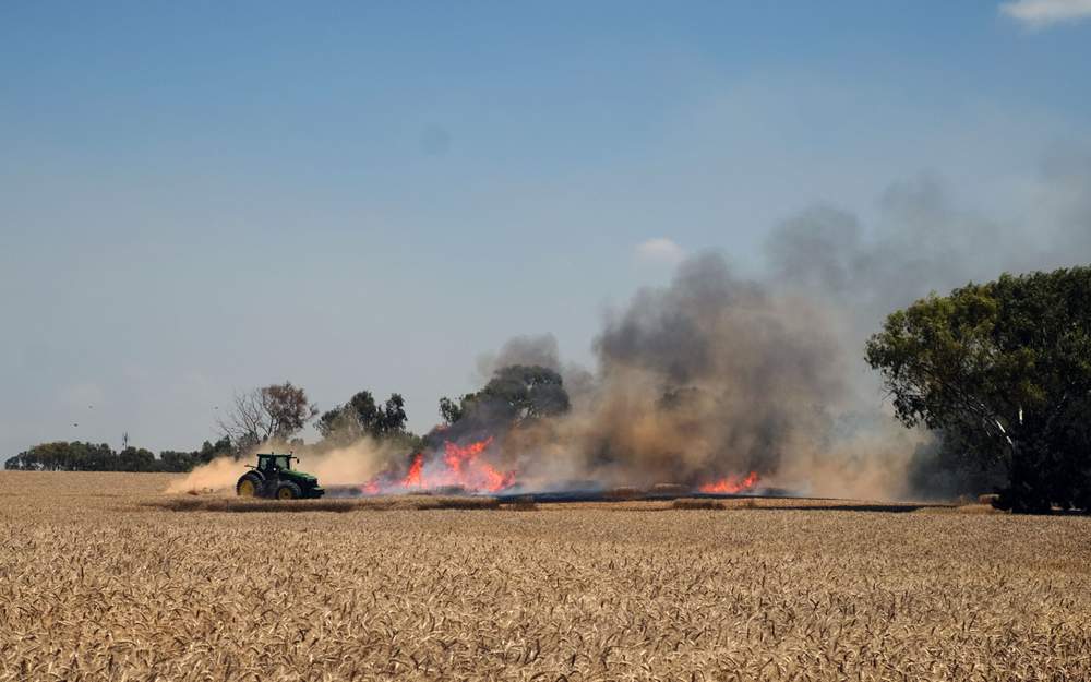 Un agricultor israelí apaga un incendio en su campo de trigo que comenzó con una cometa incendiaria procedente de Gaza, en las afueras del Kibutz Nahal Oz en el sur de Israel, el 14 de mayo de 2018. (Judah Ari Gross / Times of Israel)