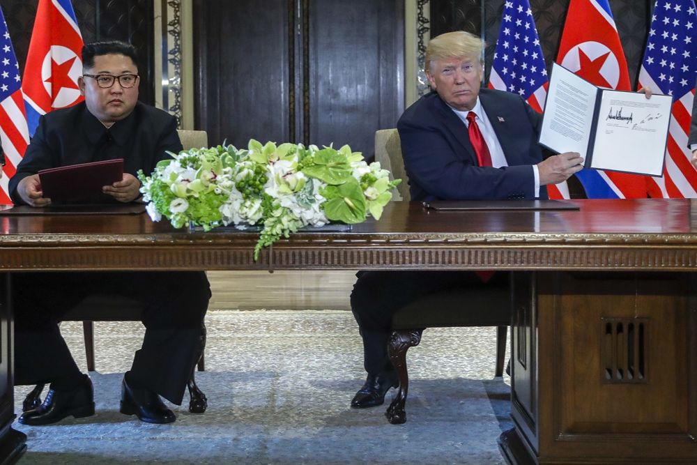 El presidente estadounidense, Donald Trump, sostiene el documento que él y el líder norcoreano Kim Jong Un acababan de firmar en el complejo Capella en la isla Sentosa, el 12 de junio de 2018 en Singapur. (AP Photo / Evan Vucci)