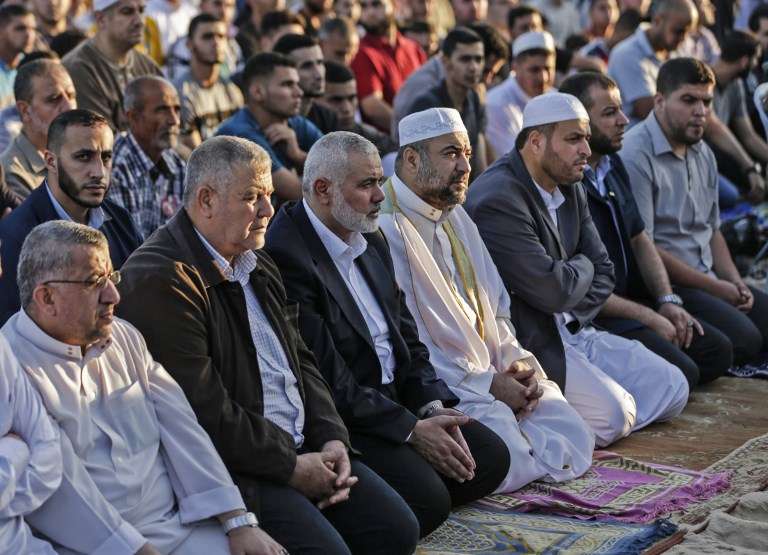 El líder de Hamás Ismael Haniyeh (3.° izquierda) asiste a las oraciones matutinas durante el primer día de las celebraciones de Eid al-Fitr, en la frontera de Israel y Gaza al este de la ciudad de Gaza el 15 de junio de 2018. (AFP PHOTO / MAHMUD HAMS)