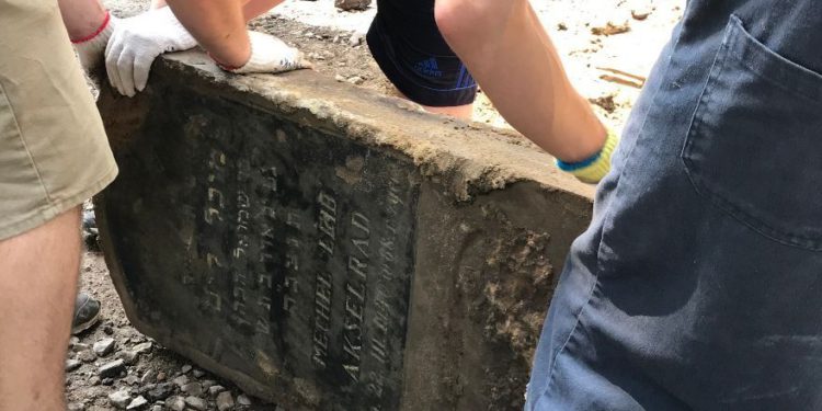 Voluntarios rescatan lápidas judías utilizadas para pavimentar una calle en Ucrania