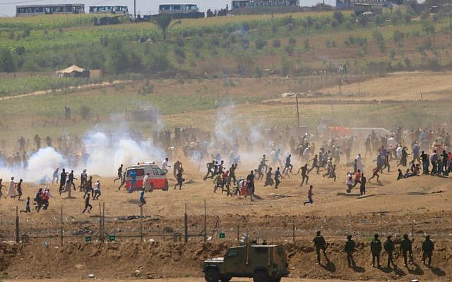 Los islamistas palestinos huyen del gas lacrimógeno disparado por soldados israelíes durante la oleada de violencia islamista a lo largo de la valla fronteriza de la Franja de Gaza el 8 de junio de 2018. (AP Photo / Ariel Schalit)