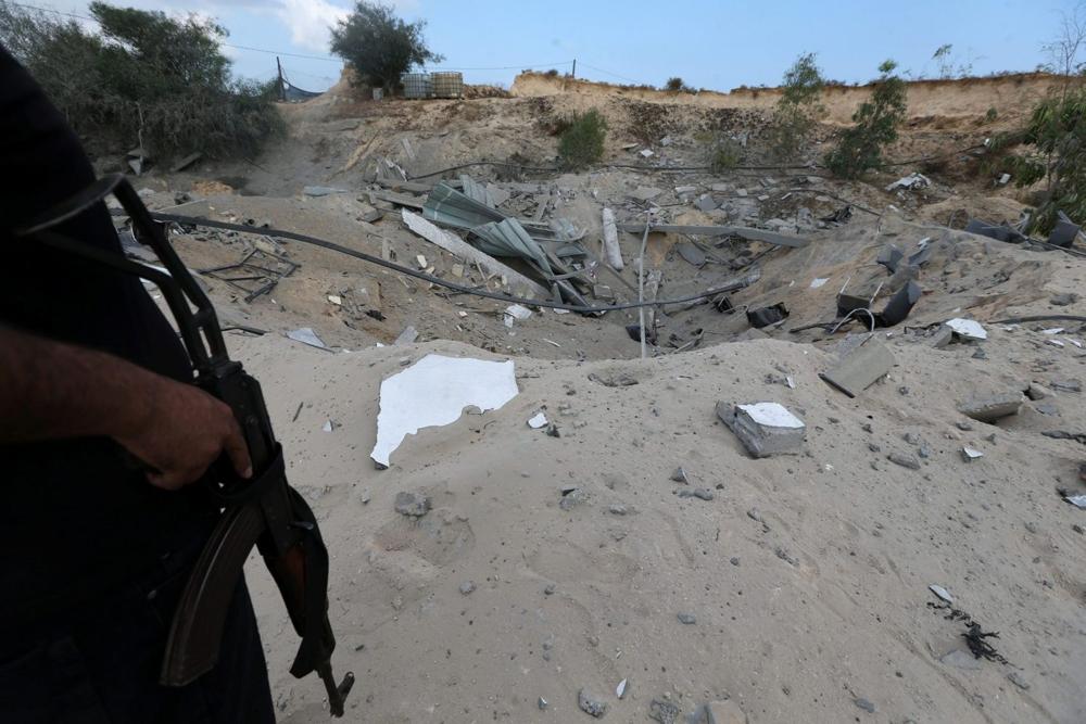 Un militante palestino monta guardia cerca de la base militar destruida de la Jihad Islámica luego de ser blanco de un avión de combate israelí, el sur de la Franja de Gaza el 30 de mayo de 2018. IBRAHEEM ABU MUSTAFA / REUTERS