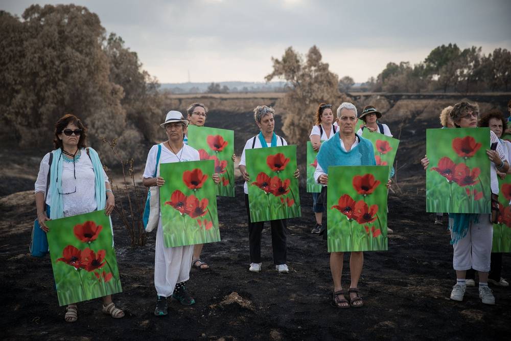 Miembros del movimiento Mujeres por la Sagrada Paz marchan en la zona quemada de Besor Stream en Tel Gama, cerca de Kibbutz Re'im, mientras demuestran solidaridad con las mujeres de las áreas que limitan con la Franja de Gaza, el 28 de junio de 2018. (Hadas Parush / Flash 90)