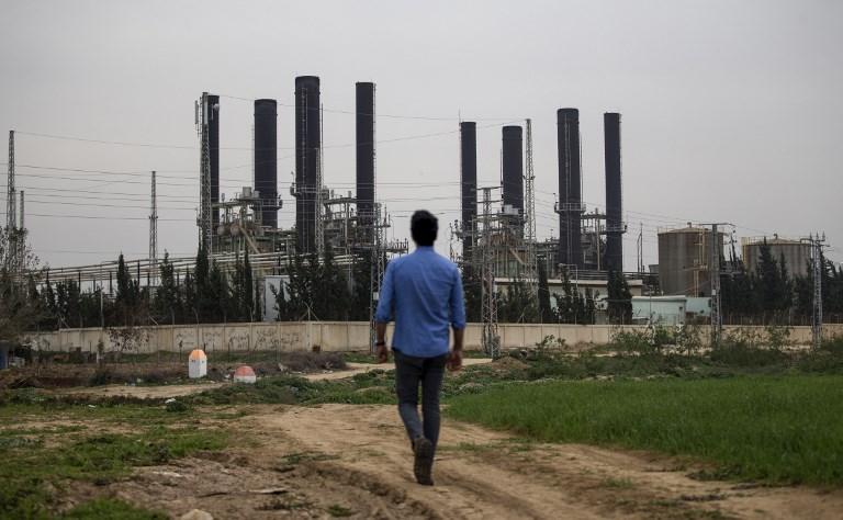 Un joven palestino camina hacia la única planta de electricidad de la franja de Gaza, que proporciona una quinta parte de las necesidades energéticas de la región, después de que dejó de funcionar a la medianoche de la noche anterior debido a la falta de combustible según funcionarios locales, el 15 de febrero de 2018. (MOHAMMED ABED / AFP)