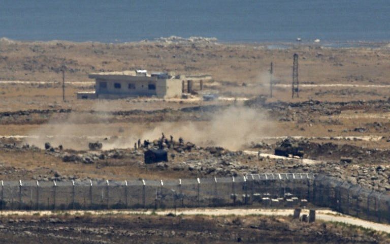 Una imagen tomada el 16 de julio de 2018 de los Altos del Golán israelí muestra cómo los combatientes rebeldes sirios junto a un tanque y un arma de artillería se acumulan cerca de la frontera en la provincia de Quneitra, al sureste de Siria, mientras las fuerzas del gobierno presionan su asalto sobre el área. (AFP Photo / Jalaa Marey)