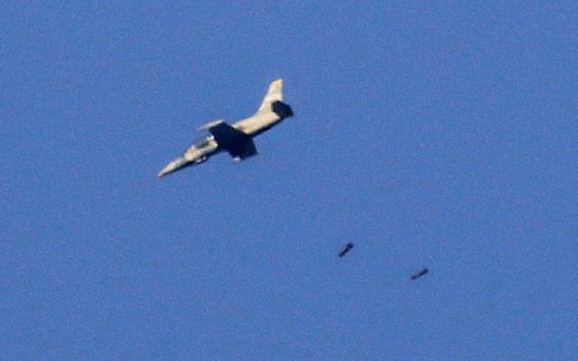 Una foto tomada el 23 de julio de 2018 desde los Altos del Golán, anexionados por Israel, muestra un avión de guerra que arroja una carga en la provincia suroccidental de Daraa, en Siria, durante una ofensiva liderada por el gobierno sirio en la zona. (AFP / JALAA MAREY)