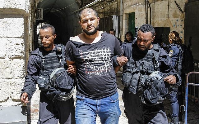Las fuerzas de seguridad israelíes detienen a un musulmán que fue arrestado durante los enfrentamientos en el complejo del Monte del Templo en la Ciudad Vieja de Jerusalén el 27 de julio de 2018. (AFP Photo / Ahmad Gharabli)