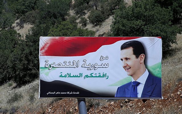 Un cartel del presidente sirio, Bashar Assad, en árabe, que dice "Bienvenido en la victoriosa Siria", se exhibe en la frontera entre Líbano y Siria, el 20 de julio de 2018. (Hassan Ammar / AP)