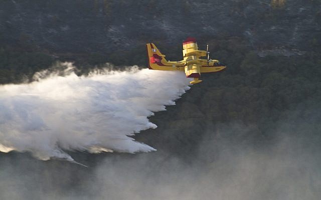 Un avión griego de extinción de incendios rocía material extintor sobre el incendio forestal en llamas en las montañas Carmel, cerca de la ciudad norteña de Haifa, Israel, el 5 de diciembre de 2010. (Doron Horowitz / FLASH90)