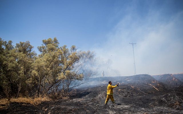 Bomberos israelíes extinguen un incendio en un campo en el sur de Israel, que fue causado por cometas voladas por palestinos en la Franja de Gaza, el 20 de junio de 2018. (Yonatan Sindel / Flash90)