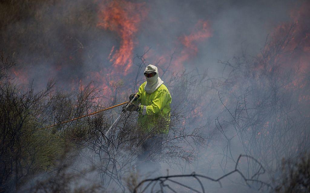 Una foto ilustrativa de un bombero que apagaba un incendio en un campo cerca de la Franja de Gaza que fue provocado por un objeto en llamas que volaba desde el enclave palestino, el 5 de junio de 2018. (Yonatan Sindel / Flash 90)