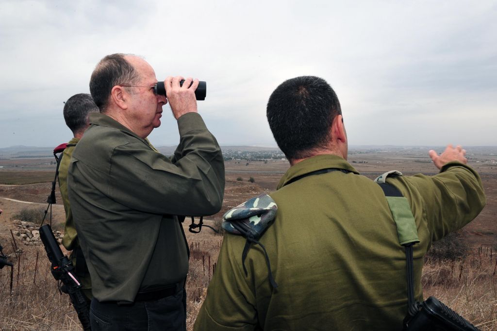 El entonces ministro de Defensa Moshe Ya'alon observa el territorio sirio desde los Altos del Golán el 3 de diciembre de 2013. (Crédito de la foto: Ariel Hermoni / Ministerio de Defensa / Flash 90)