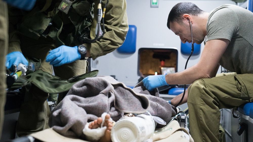 Los médicos del ejército israelí brindan atención a un sirio herido que fue llevado a Israel para recibir tratamiento médico el 29 de junio de 2018. (Fuerzas de Defensa de Israel)