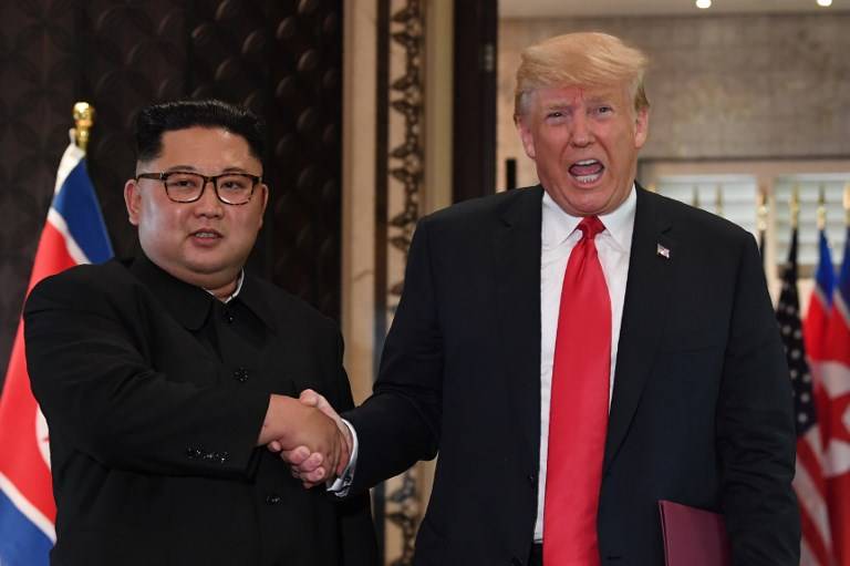 El presidente estadounidense Donald Trump (R) y el líder norcoreano Kim Jong Un se dan la mano tras una ceremonia de firma durante su histórica cumbre EEUU-Corea del Norte, en el Hotel Capella en la isla Sentosa en Singapur el 12 de junio de 2018. (AFP PHOTO / SAUL LOEB )