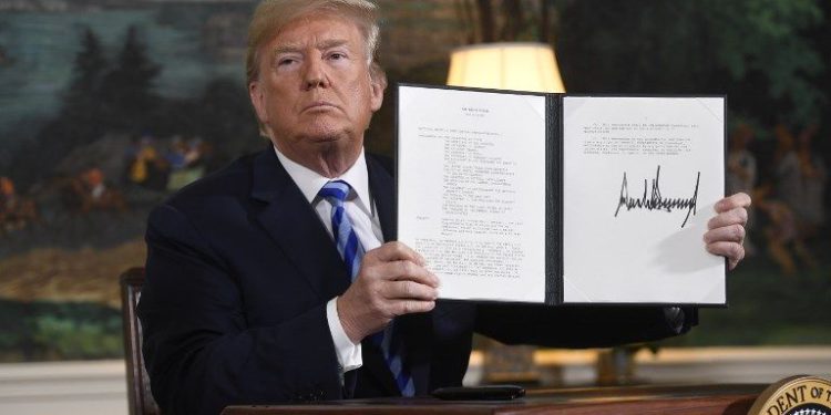 El presidente estadounidense Donald Trump firma un documento que restablece las sanciones contra Irán después de anunciar la retirada de Estados Unidos del acuerdo nuclear de Irán, en la sala de recepción diplomática en la Casa Blanca en Washington, DC, el 8 de mayo de 2018. (AFP PHOTO / SAUL LOEB)