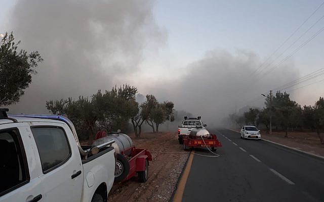 Los oficiales de seguridad locales trabajan para apagar un incendio, provocado por globos incendiarios de la Franja de Gaza, en el área de Hevel Shalom, en el sur de Israel, el 26 de junio de 2018. (Seguridad Eshkol)